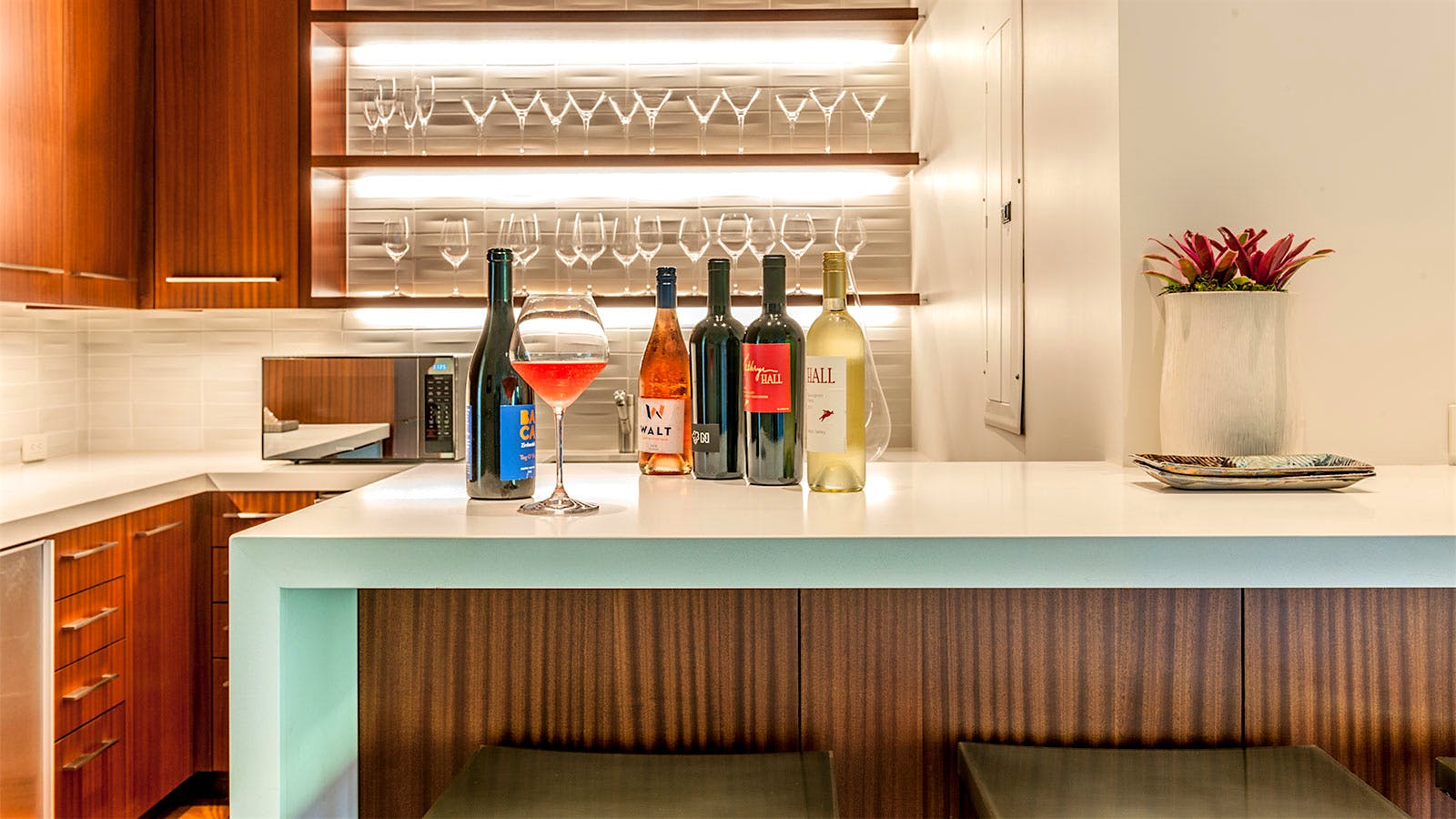 A wine pantry with coolers and shelves of glassware