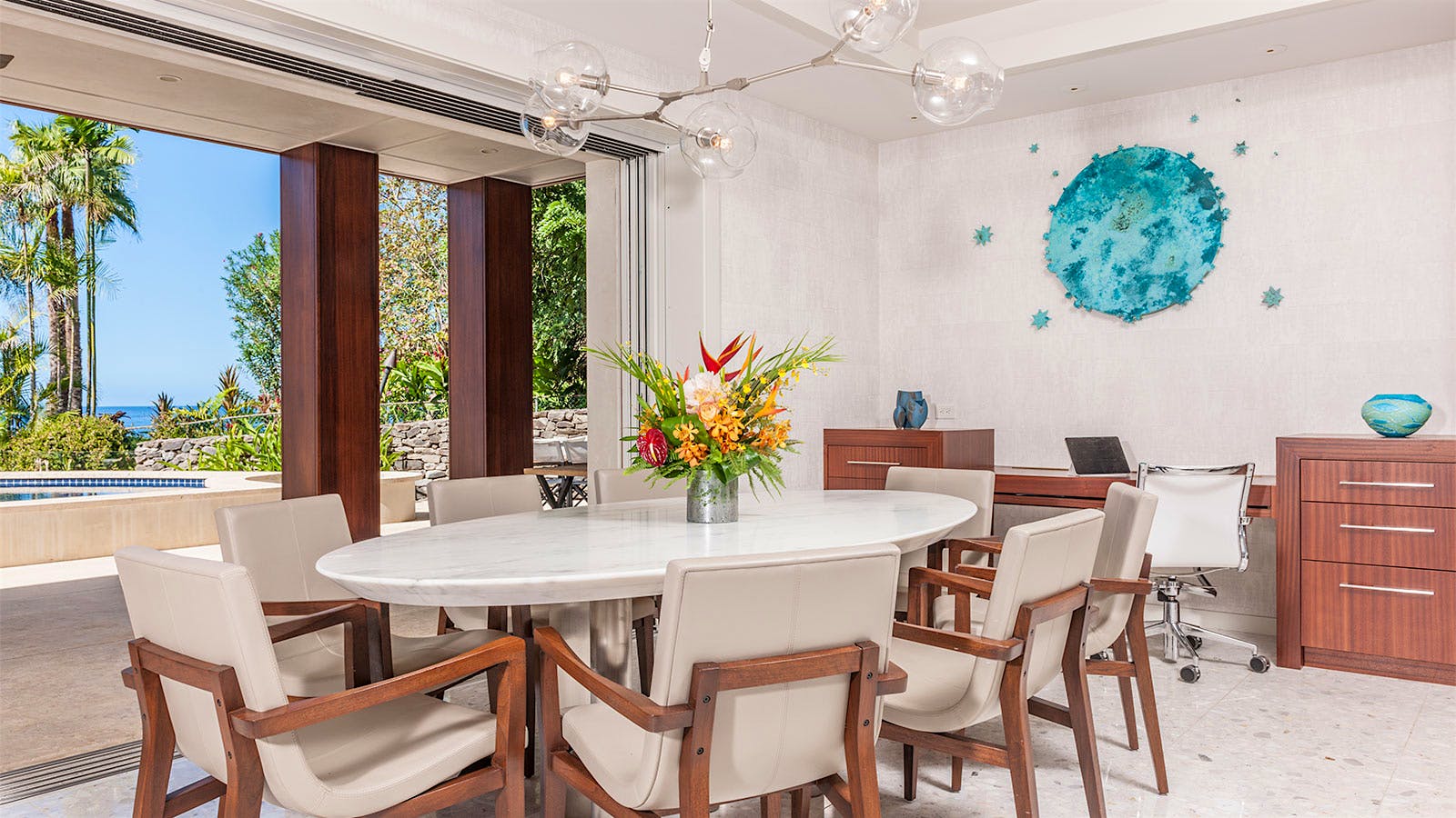 Dining room with floor-to-ceiling windows and a white marble–topped table.